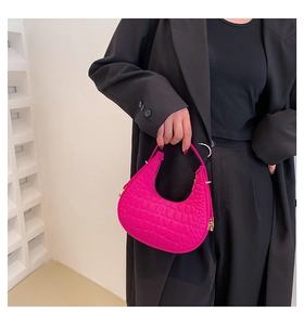 Dettaglio della borsa a mezzaluna fucsia a motivo coccodrillo con fibbie dorate