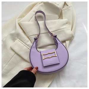 Fashionable purple crescent hobo bag with gold hardware on beige blazer background