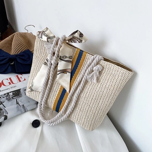 Detailed texture of beige woven straw tote bag with colorful stripes and cotton rope handle