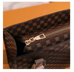 Detail presentation of smooth golden metal zipper and brown textured leather handbag