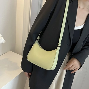 Dettaglio della borsa hobo verde chiaro con tracolla regolabile su un blazer nero