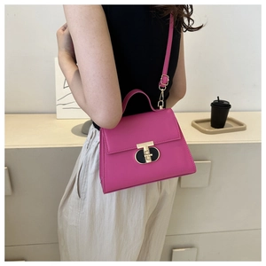 Magenta square crossbody bag with gold geometric lock and sleek leather texture