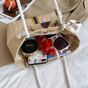 Macro shot of spacious straw tote bag interior showing capacity for cosmetics and accessories