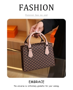 Detail of vintage monogram handbag with brown leather texture and beige handles