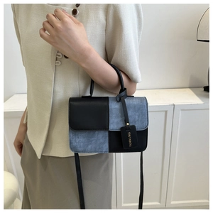 Détail du sac à main avec patchwork en denim et accessoire d'étiquette de mode