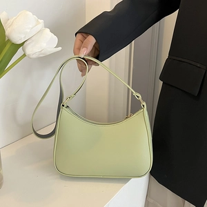 Dettaglio della borsa a mezzaluna verde menta in pelle opaca con hardware dorato