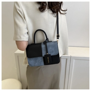 Détail du sac à bandoulière bicolore avec sangle réglable et pendentif décoratif de mode