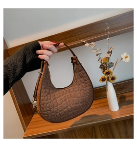 Dettaglio della borsa hobo marrone con motivo coccodrillo e fibbia in metallo