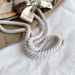 Detail of colorful woven straw tote with thick cotton rope handle and silk scarf decor