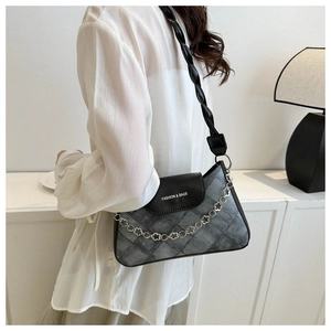Détail du sac matelassé gris vintage avec chaîne à fleurs et bandoulière en cuir