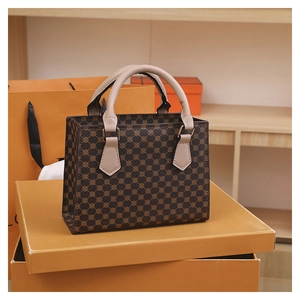 Macro shot of dark brown vintage pattern tote bag with light pink leather straps and hardware