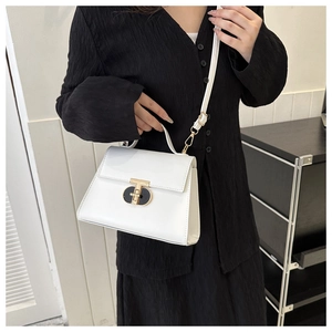 Close-up of a white patent leather handbag featuring a gold T-shaped twist lock buckle