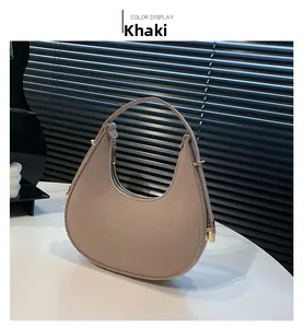 Detail view of khaki felt crescent bag with neat stitching and gold zipper hardware