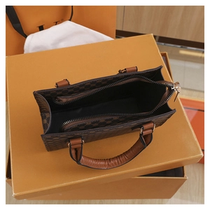 Top view of a brown vintage patterned handbag featuring internal zipped compartments
