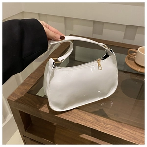 Gros plan du sac sous le bras en cuir verni blanc avec finition brillante et zip doré