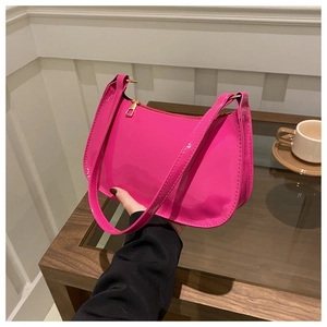 Dettaglio borsa sottobraccio in pelle verniciata rosa acceso con cerniera dorata