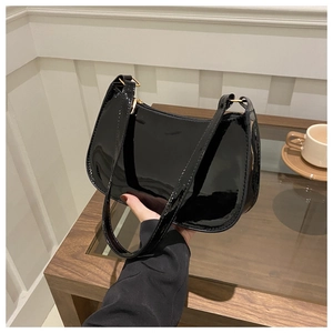 Dettaglio borsa hobo in pelle verniciata nera lucida con fibbie dorate e tracolla