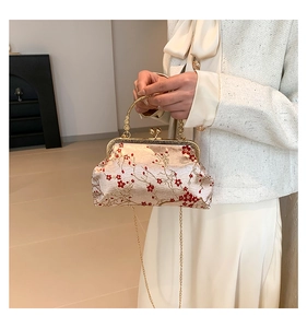 Detail of vintage Chinese embroidery bag with red plum blossoms and gold metal handle