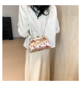 Close-up of Chinese retro shell bag with red plum blossom embroidery and gold chain strap