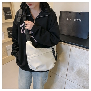 Detail of white nylon crescent bag with contrast black zipper and wide shoulder strap