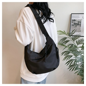 Detail of black hobo bag with thick woven rope zipper and adjustable wide strap