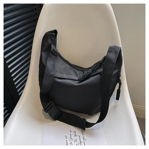 Detail of black nylon crescent bag featuring wide shoulder strap and plastic buckle