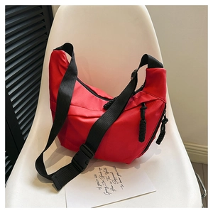 Detail of red crescent crossbody bag with thick rope zipper and black nylon strap