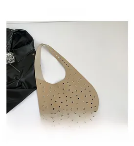 Detailansicht der khakifarbenen Ledertasche mit silbernen Punk-Nieten und Ösenverzierung