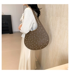 Braune Hobo-Tasche aus Leder mit stilvollen silbernen Metallösen und Schultergurt