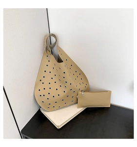 Detailansicht der beigen Kunstledertasche mit modernen metallischen Ösenakzenten