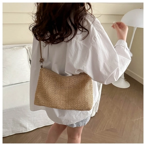 Detail of hand-woven mesh texture on a khaki summer beach straw shoulder bag