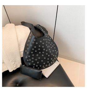 Detail der schwarzen Hobo-Beuteltasche aus Leder mit Silberösen und kleinem Beutel
