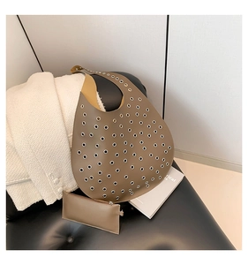 Detail einer braunen Leder-Tragetasche mit Metallösen und passendem Münzfach im Set