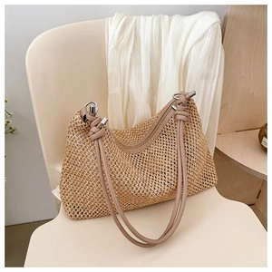 Detail of straw shoulder bag showing woven texture, PU handles and silver metal rings
