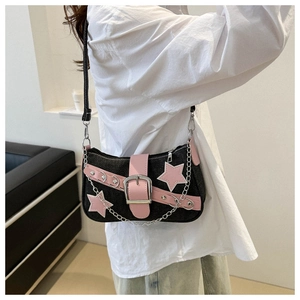 Detail of dark denim baguette bag with pink leather belt, star patch and silver buckle