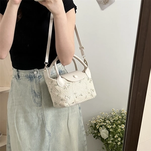 Chic beige woven handbag with green floral embroidery and adjustable crossbody strap