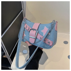 Detailed shot of a Y2K denim underarm bag with pink star patches and silver chain