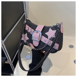 Detail of Y2K denim shoulder bag with pink leather stars and silver chain accents