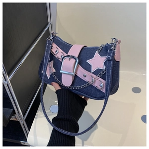 Detail of Y2K denim underarm bag featuring pink star patches and metallic chain straps