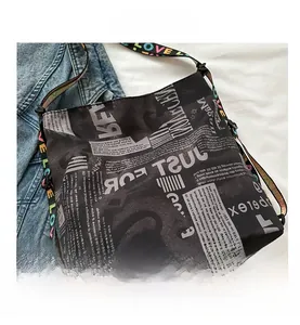 Detail der Canvas-Tasche mit Zeitungsdruck und farbenfrohem LOVE-Schultergurt-Design