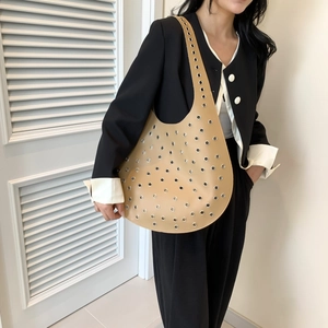Chic beige Halbmond-Hobo-Tasche mit silbernen Ösen als Schultertasche getragen