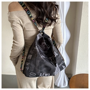 Rear view of a fashion newspaper print drawstring bag with colorful love strap decoration
