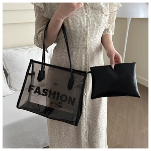 Detail of grey transparent tote bag with black inner pouch and FASHION logo print