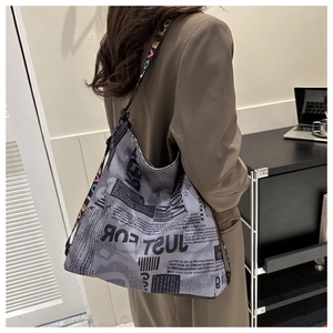 Detail of vintage newspaper print bucket bag with colorful LOVE letter wide strap