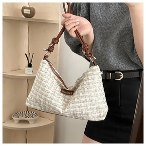 Detail of tweed crossbody bag with brown leather knotted strap and gold metal hardware