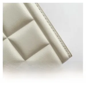 Gros plan sur la texture du cuir beige matelassé avec surpiqûres de haute qualité