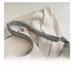 Detail of adjustable silver shoulder strap with metallic buckle on a large tote bag
