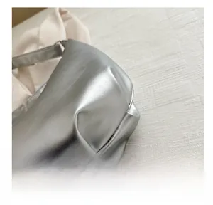 Macro detail of silver metallic tote bag featuring premium leather texture and stitching