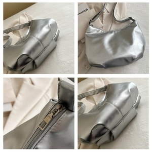Detail of silver metallic hobo bag featuring smooth zipper and polished streamline finish