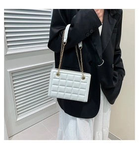 Détail du sac bandoulière blanc en similicuir matelassé avec chaîne dorée et épaulière